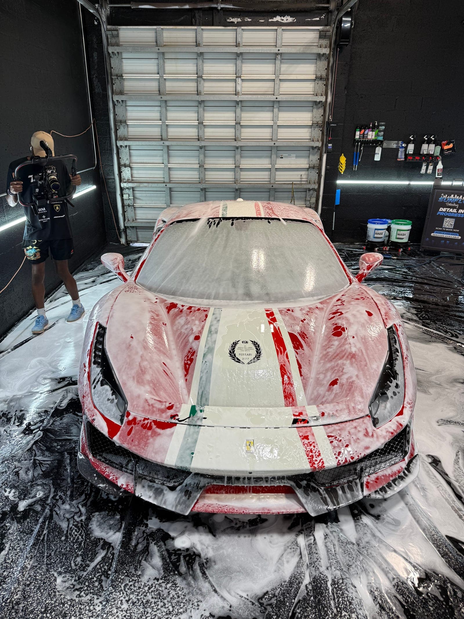 Ferrari 488 Pista under a full snow foam bath during a hand wash at the Fort Lauderdale studio