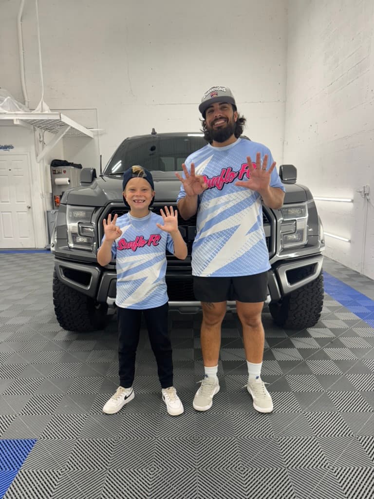 Jason and crew inside the Oakland Park shop in front of a Ford Raptor