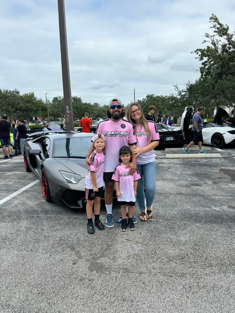 Sunflo team at a South Florida car show alongside a matte gray Lamborghini Aventador