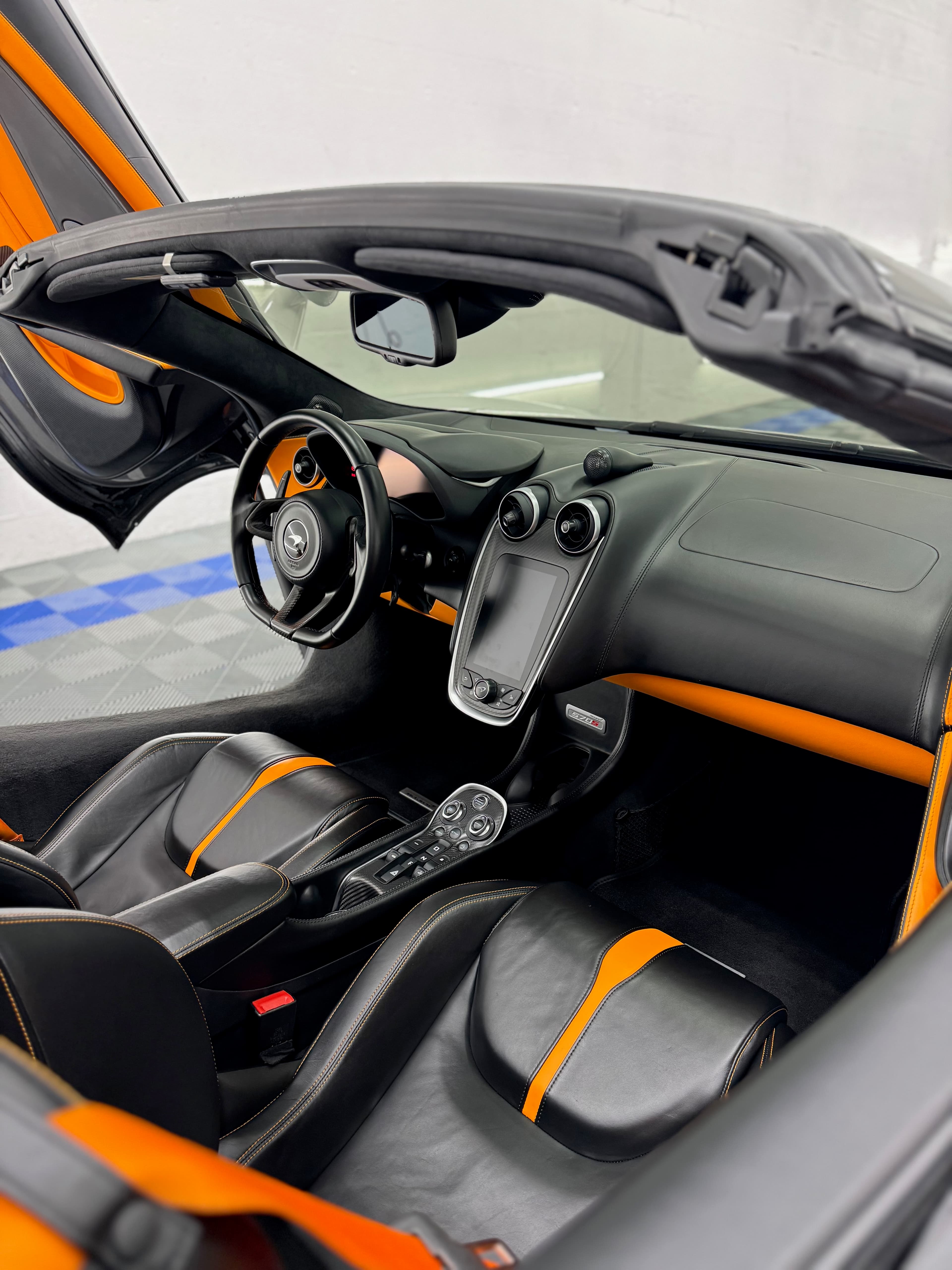 McLaren 12C interior with carbon fiber trim and contrasting orange leather accents after a full interior detail