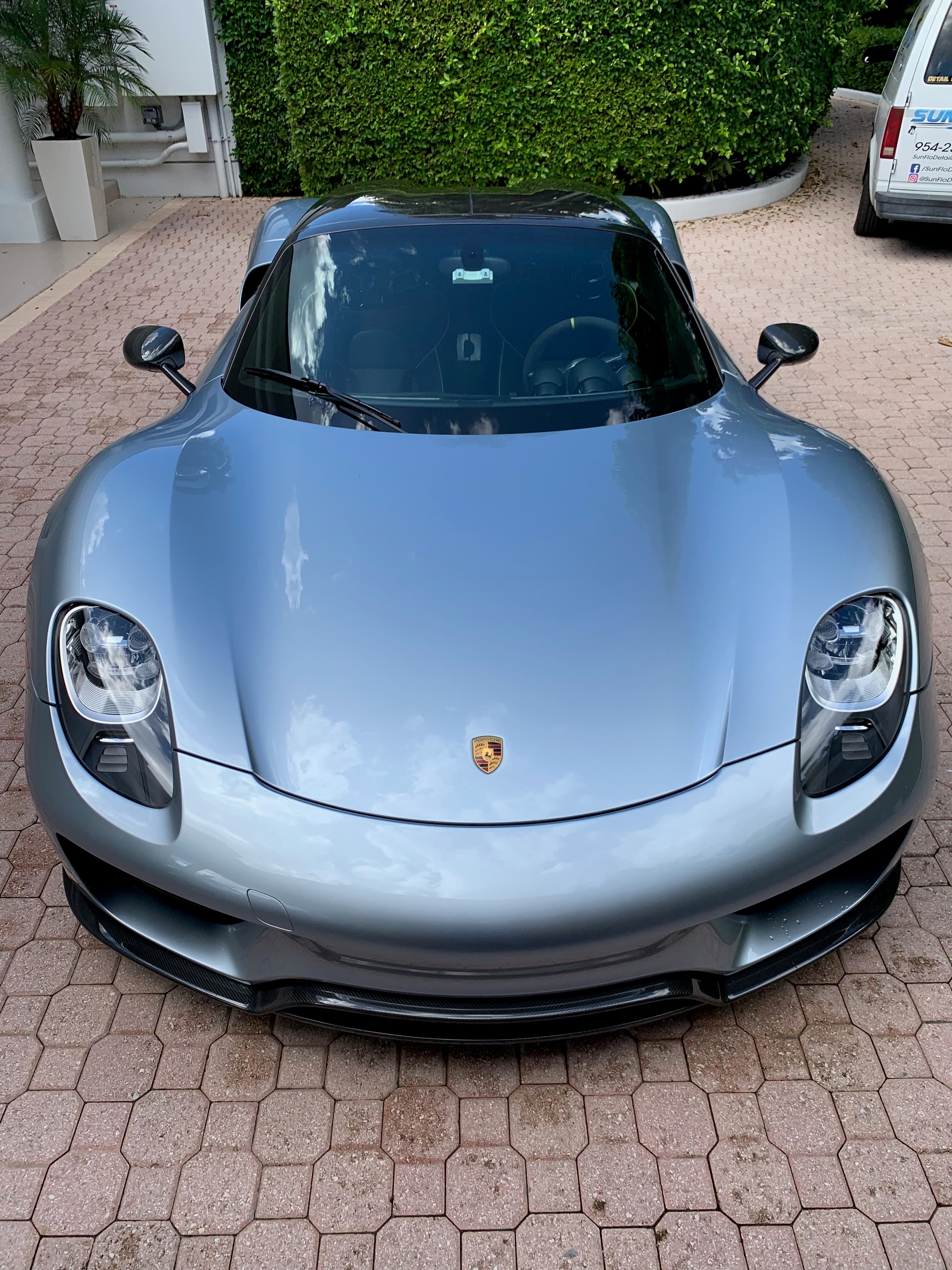 Silver Porsche 918 Spyder photographed from above on a brick driveway after a full exterior detail